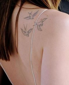 the back of a woman's shoulder with birds on it