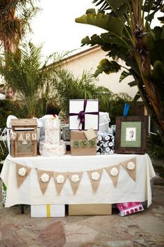 a table that has some pictures on it and decorations in front of the table is covered with white cloths