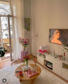 a living room filled with furniture and a painting on the wall next to a window