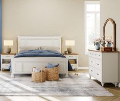 a white bed sitting in a bedroom next to a dresser and mirror on top of a wooden floor