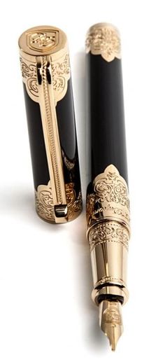 two black and gold fountain pens sitting next to each other