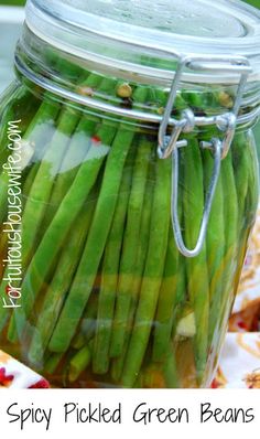 a jar filled with pickled green beans on top of a table