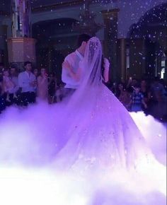 a bride and groom are kissing in the clouds