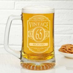 a glass mug with the number 66 on it next to a bowl of cookies and a white brick wall