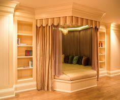 a bed sitting inside of a bedroom next to a book shelf filled with lots of books