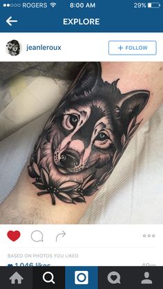 a black and white wolf tattoo on the right arm, with flowers around its neck