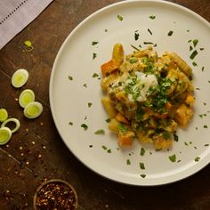 a white plate topped with food and garnished with parsley next to sliced onions