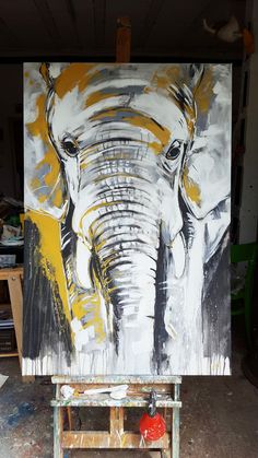 an elephant painting is being displayed on a easel