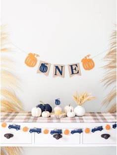 a table with pumpkins and bunting banner on it for an empty nest home goods party