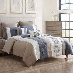 a bed with blue and white comforters in a room