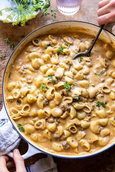 a pan filled with macaroni and cheese on top of a wooden table