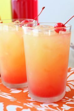 two glasses filled with drinks sitting on top of a table