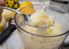 a person scooping sugar into a food processor