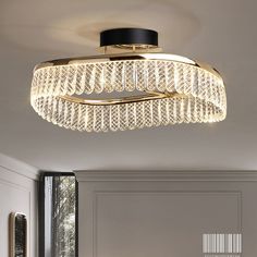 a modern style chandelier with crystal beads hanging from the ceiling in a living room