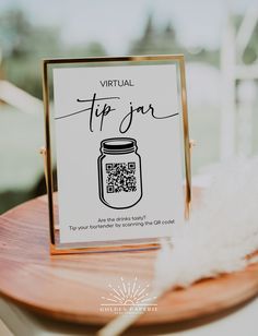 a table with a sign that says virtual tip jar on it and a white feather