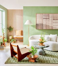 a living room with green walls and white furniture