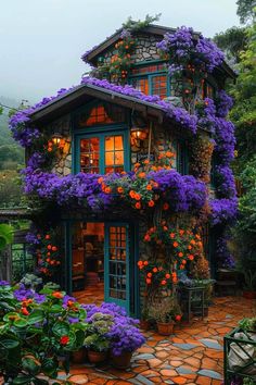 a house with purple flowers growing on the outside and green trimming around it's windows