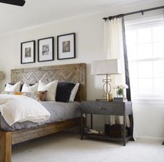 a bedroom with a bed, nightstands and pictures on the wall