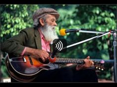 an old man with a long white beard playing guitar