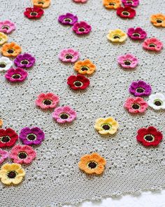 crocheted flowers are arranged on a blanket