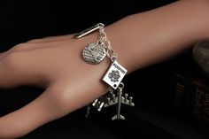 "A collection of silver plated travel and tourism themed charms have been dispersed around a shimmering silver plated bracelet chain in this handmade charm bracelet. This world traveler charm bracelet is then completed with a lobster clasp and a 1/2 inch of chain at the end for adjustable sizing. Charms in this bracelet include an airplane charm, passport charm, \"find joy in the journey\" charm, world charm, camera charm, \"bon voyage\" charm, suitcase charm, binoculars charm, and compass charm Silver Metal Jewelry For Travel, Nickel-free Silver Bracelets As Souvenir, Silver Nickel-free Bracelet Souvenir, Adjustable Silver Jewelry For Travel, Camera Charm, Find Joy In The Journey, Travel Bracelet, Handmade Charm Bracelets, Joy In The Journey