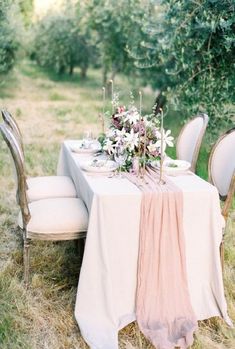 the table is set with flowers and place settings