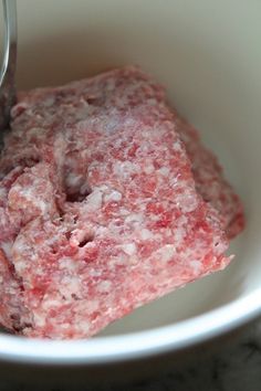 a close up of food in a bowl with a spoon on the side and a fork sticking out of it