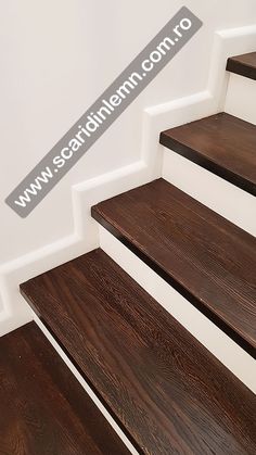 wooden stairs with white handrails and dark wood flooring