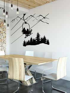 a dining room table with chairs and a wall decal that has a silhouette of two people on a ski lift