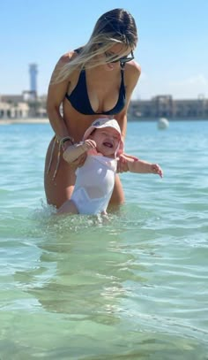 a woman holding a baby in the water