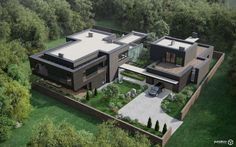 an aerial view of a modern house in the middle of trees and grass, with two cars parked on the driveway