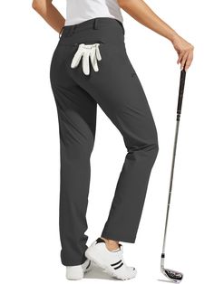 a woman in grey pants holding a golf club