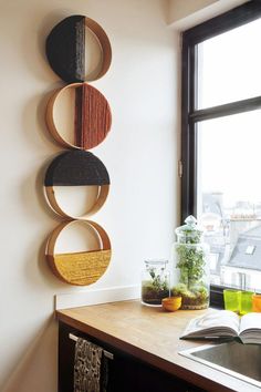 a kitchen counter topped with a wooden shelf filled with plants and potted plants next to a window