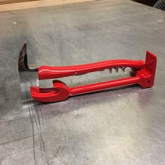 a red wrench sitting on top of a metal table