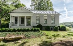 a white house sitting on top of a lush green field