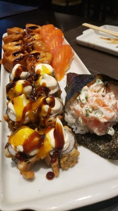 a white plate topped with different types of sushi and other foods on top of it