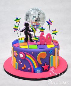 a birthday cake with a disco ball and stars on top is decorated in bright colors