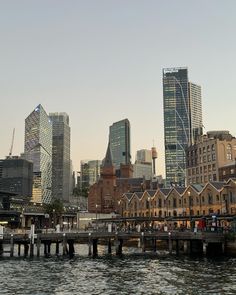 the city skyline is seen from across the water in front of some tall skyscrapers