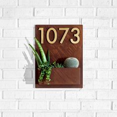 a wooden sign that says 1033 with succulents and cactus in it