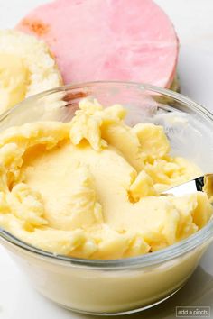 a bowl filled with mashed potatoes on top of a white counter next to a pink heart