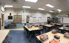 an empty classroom with desks and books