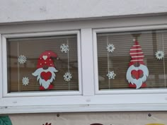 two windows with christmas decorations on them and snowflakes in the window sill