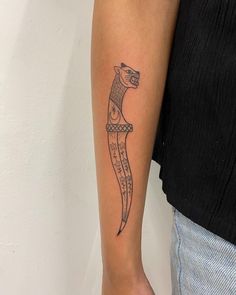 a woman's arm with a tattoo on it that looks like a cat sitting on top of a banana