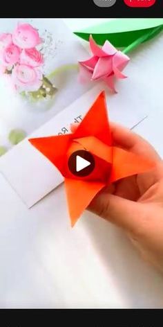 someone is holding an origami star in their left hand and pointing to it