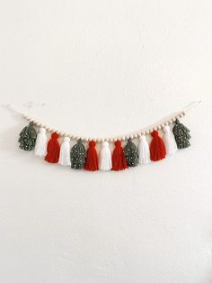 a white wall with red and green tassels hanging from it