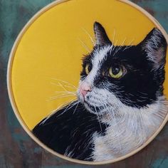 a black and white cat painted on a yellow circle