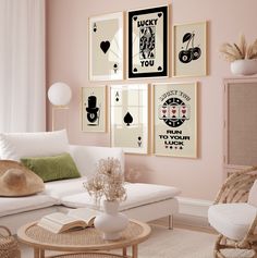 a living room with pink walls and pictures on the wall, including a white couch