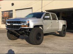 a silver truck parked in front of a garage