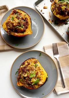 two plates filled with stuffed peppers on top of a table