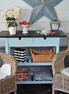 two wicker chairs sitting in front of a blue table with baskets and fruit on it